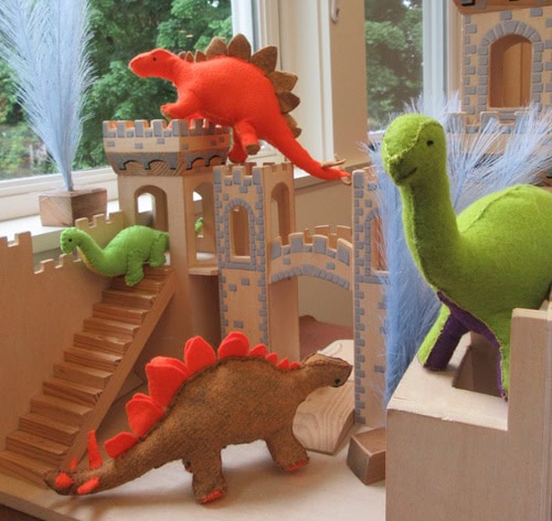 photo of handmade felt dinosaurs toys in a toy wooden castle
