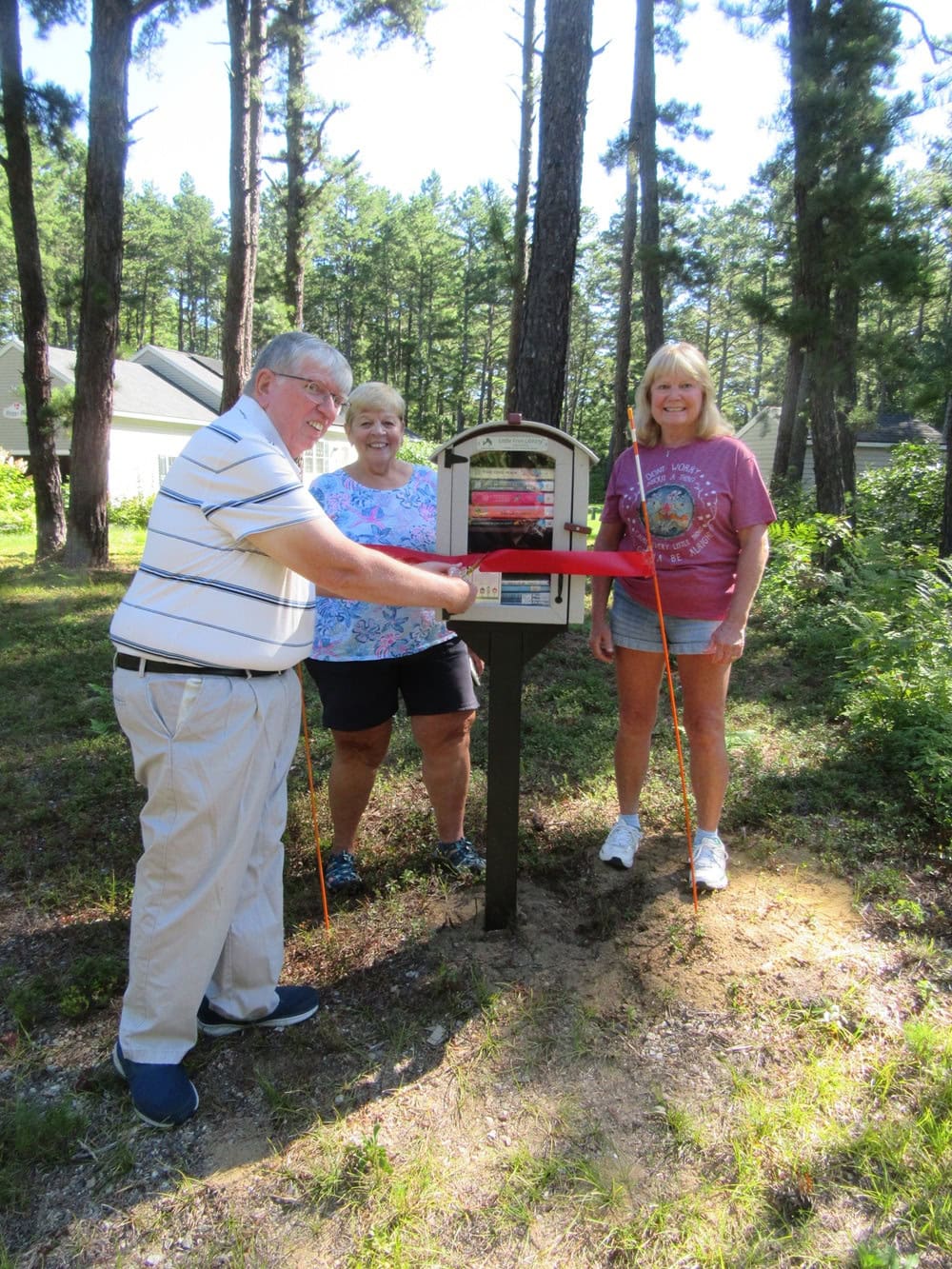 photo of three people standing next to a Little Free Library in Tamworth