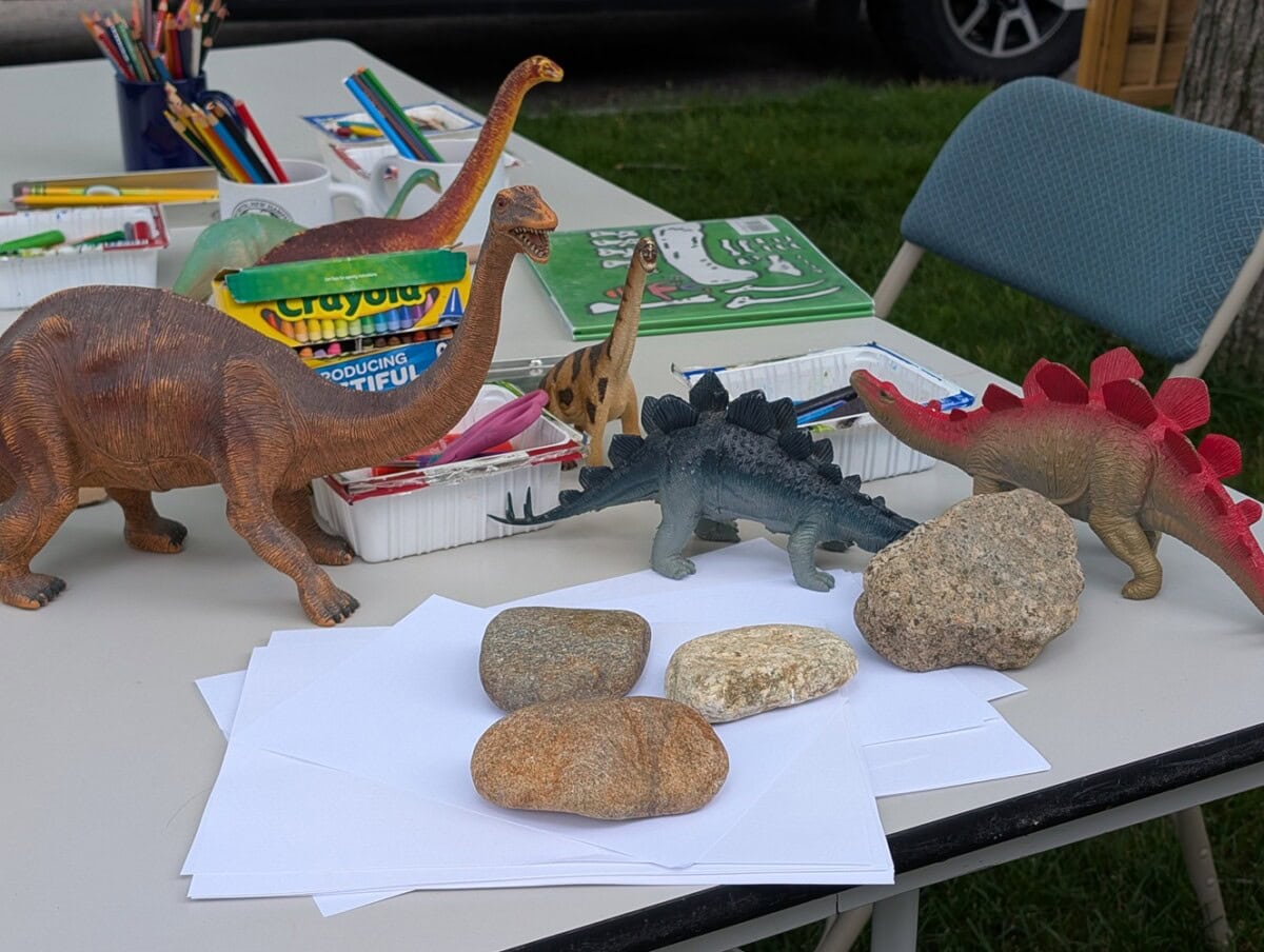photo of art supplies on a table with toy dinosaurs